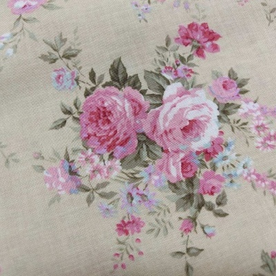 Tecido bege com padrão floral em tons de rosa, lilás e verde