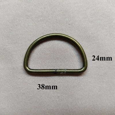 D-ring metálico bronze sobre tecido creme com medidas 24mm e 38mm indicadas