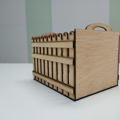 Caixa de madeira organizadora com alça sobre mesa branca