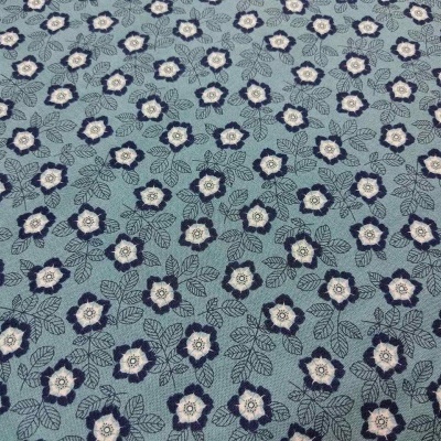 Tecido azul com padrão floral branco, azul escuro e bege