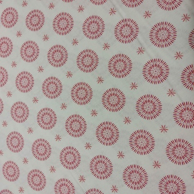 tecido branco com círculos vermelhos e pequenos asteriscos
