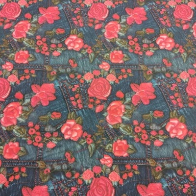 Tecido com padrão floral vermelho e rosa sobre fundo tipo jeans azul escuro