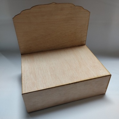 Caixa de madeira clara com tampa e parte traseira decorativa.