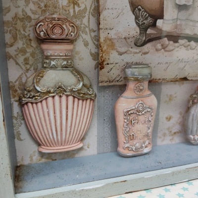 Três frascos decorativos vintage em prateleira de madeira azul