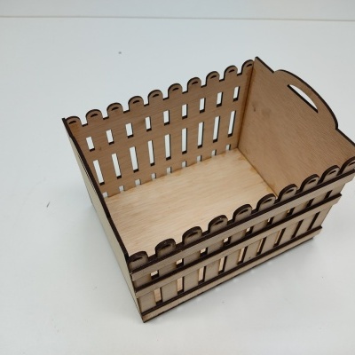 Caixa de madeira clara tipo cerca vista de cima num fundo branco