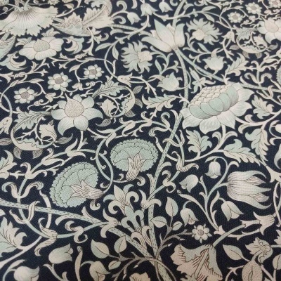 Tecido azul escuro com padrão floral bege e verde claro