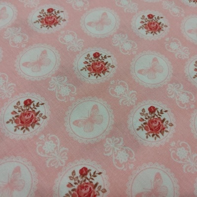 Tecido cor-de-rosa com padrão de borboletas e rosas em círculos