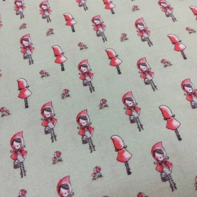 Tecido bege com padrão de pequenas figuras femininas de capuz vermelho