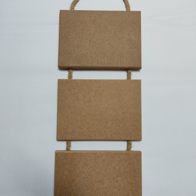 Três quadros retangulares em cortiça unidos por cordas para pendurar