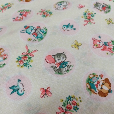 Tecido branco com estampas infantis de animais em círculos cor-de-rosa