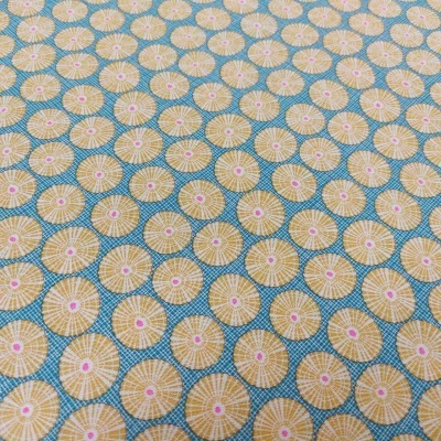 Tecido com padrão de círculos amarelos e detalhes cor de rosa em fundo azul