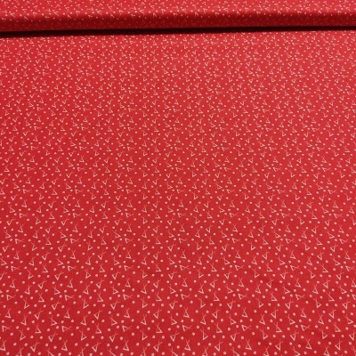 Tecido vermelho com padrão de triângulos brancos.
