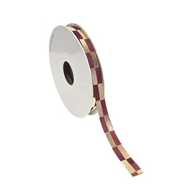 Rolo de fita quadriculada dourada, vermelha e bege.