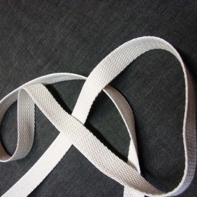 cinta têxtil branca com textura trançada sobre fundo escuro