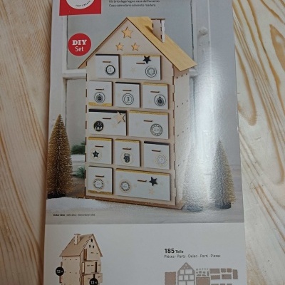 Conjunto DIY de calendário de advento casa em madeira com 24 caixas numeradas e detalhes decorativos.