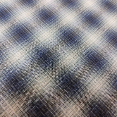 Tecido xadrez azul, branco e cinzento com textura entrelaçada