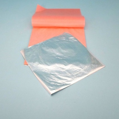 Folha de alumínio quadrada com rolo de papel cor-de-rosa no fundo azul claro