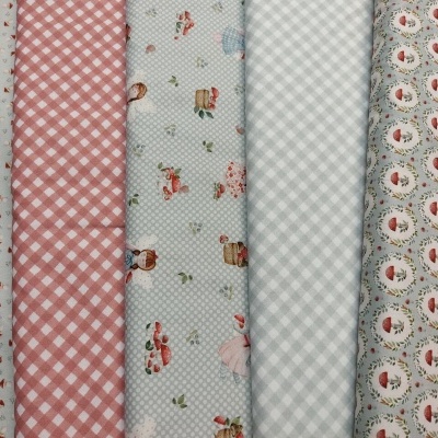 Cinco rolos de tecido com padrões variados alinhados lado a lado