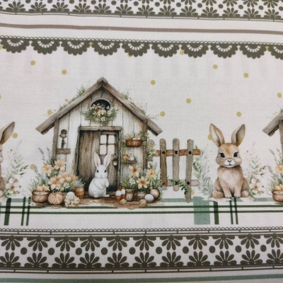 Tecido decorativo com coelhos, casinhas e flores em tons de bege, verde e castanho.