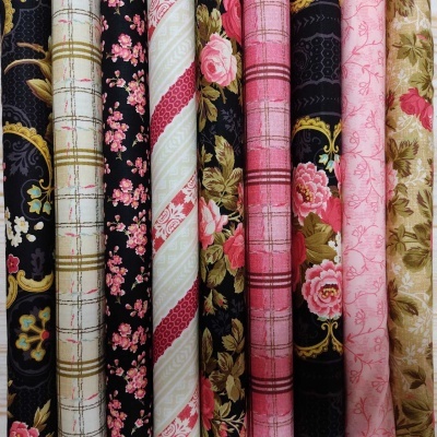 Rolos de tecido com padrões florais, listras e xadrez em cores variadas.
