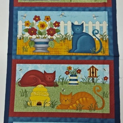 Painel de tecido decorativo com imagens de gatos, flores, cercas, colmeias e casas de pássaros em várias cores.