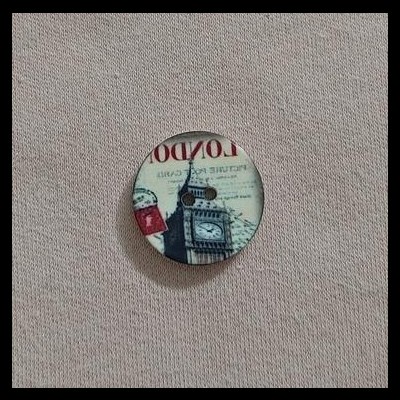 Botão redondo com imagem do Big Ben e texto 'LONDON' sobre tecido bege