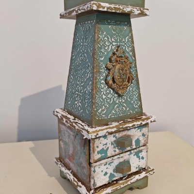 Suporte decorativo tipo torre em madeira e metal com acabamento envelhecido e detalhes em relevo