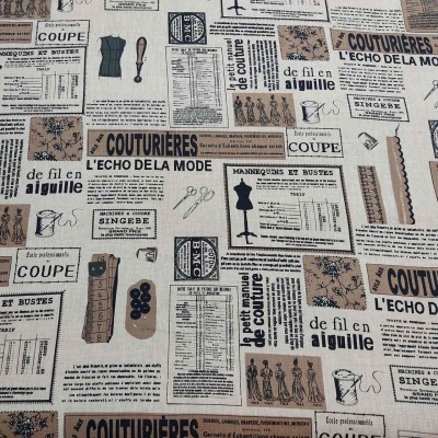 Tecido estampado com motivos e textos de costura em tons bege, castanho e preto.
