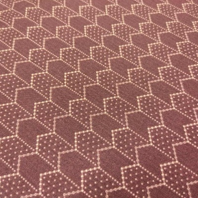 Tecido castanho com padrão geométrico em cubos brancos