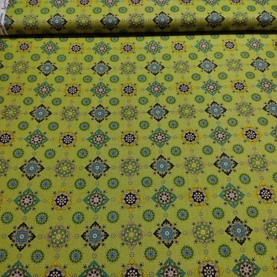 Tecido verde com padrão geométrico em azul, bege e castanho em fundo branco