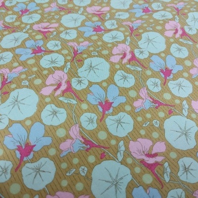 Tecido floral com folhas azuis e flores rosas em fundo castanho