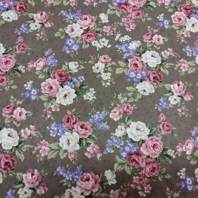 Tecido com padrão floral em tons de rosa, branco e lilás sobre fundo castanho.