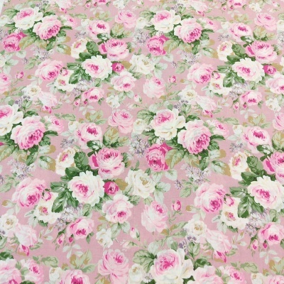 Tecido floral em tons de rosa, branco e verde sobre fundo rosa claro