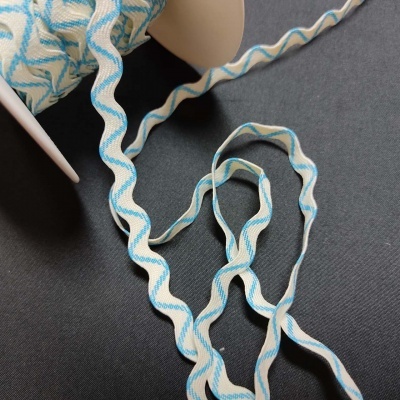 Fita branca com padrão ondulado azul enrolada num carretel