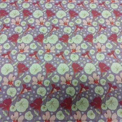 Tecido floral com folhas verdes e flores vermelhas sobre fundo cor de lavanda