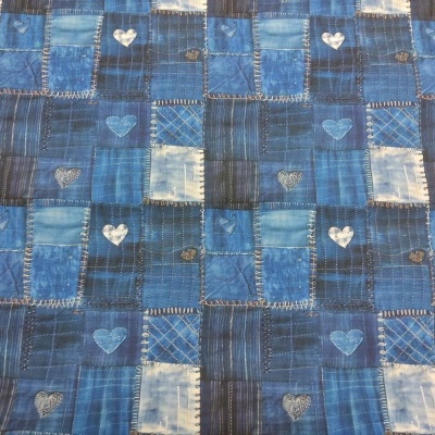 Tecido azul com padrão de remendos de denim e corações brancos e azuis.