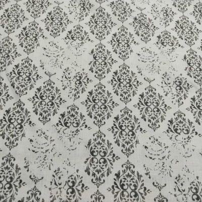 Tecido branco com padrão preto repetitivo de motivos florais e ornamentais