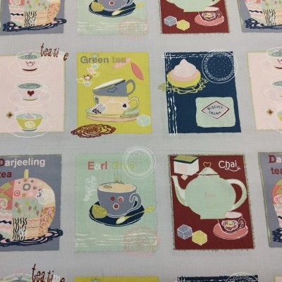 Tecido com padrão de quadrados coloridos contendo ilustrações de chá, xícaras e bolos com texto em inglês