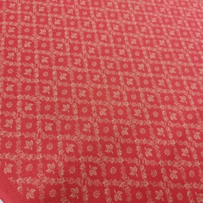 Tecido vermelho com padrão de folhas bege em quadros