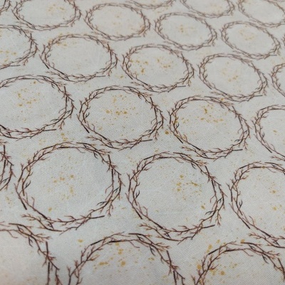 Tecido bege com círculos de ramos castanhos entrelaçados e manchas castanhas claras