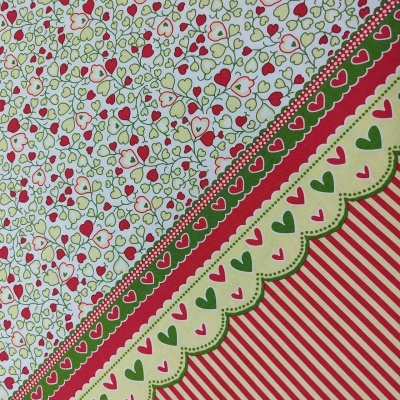 Tecido estampado com corações e linhas em vermelho, verde e creme