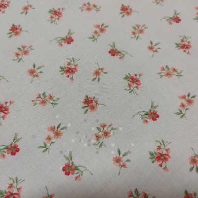 Tecido branco com padrão de pequenas flores vermelhas e rosa com folhas verdes