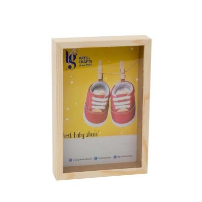 Quadro decorativo com ténis de bebé cor-de-rosa e fundo amarelo