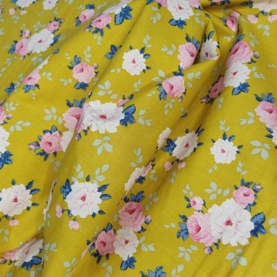 Tecido amarelo com padrão floral de rosas brancas e rosas e folhas verdes
