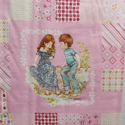 Pano de tecido rosa com padrão de quadrados coloridos e ilustração de crianças sentadas na relva