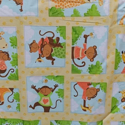 Tecido colorido com padrão de macacos e girafas em quadrados amarelos