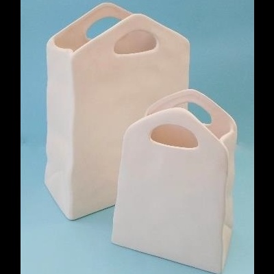 Dois objectos de cerâmica creme em forma de saco com alças recortadas