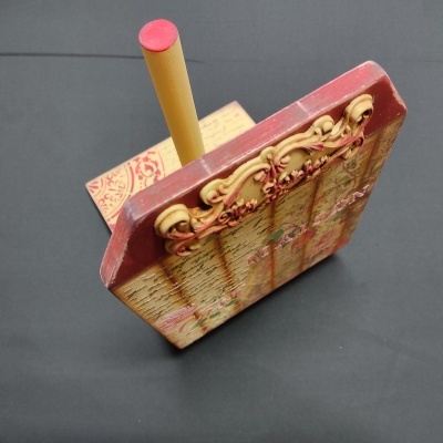 Suporte de madeira decorado com pau de incenso amarelo e vermelho