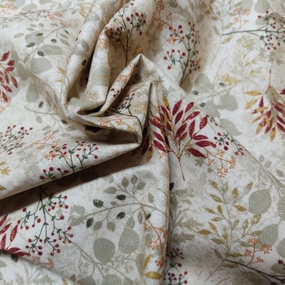 Tecido estampado com padrão floral em tons neutros e vermelhos.