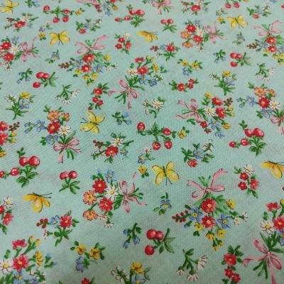 Tecido azul claro com padrão floral colorido e borboletas
